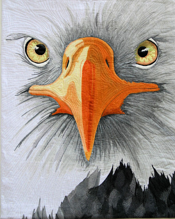 Eagle Eyes is a stunning fiber art work that shows a
 closeup view of an eagles face 