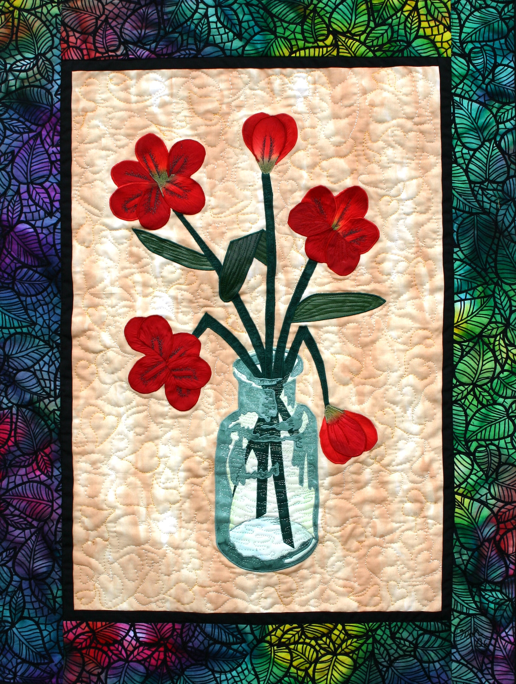 glass vase with flowers is a fiber art work showing some red flowers in a vase
with a threadpainted image of glass showing shading and shape with the use of creative stitching